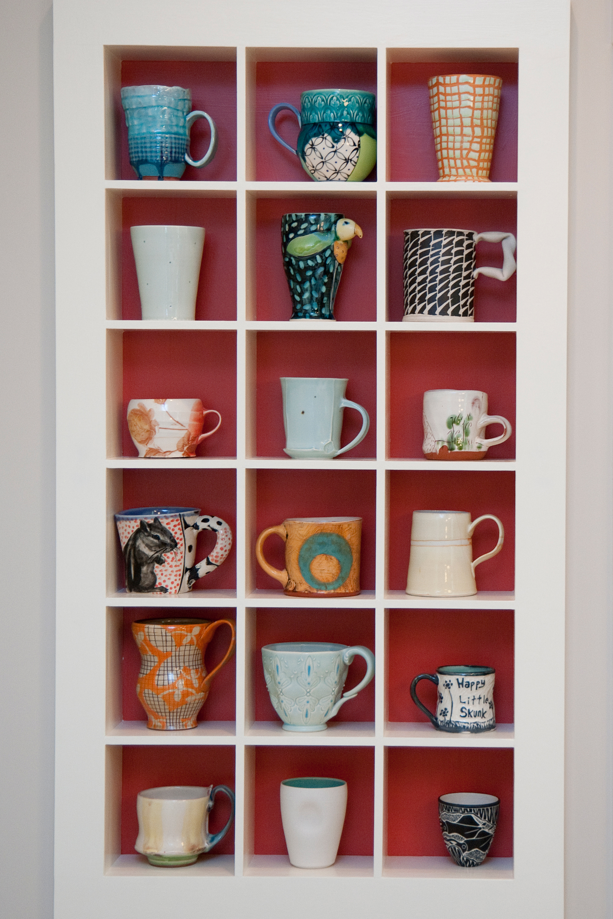 A built-in cabinet with separate compartments for mugs