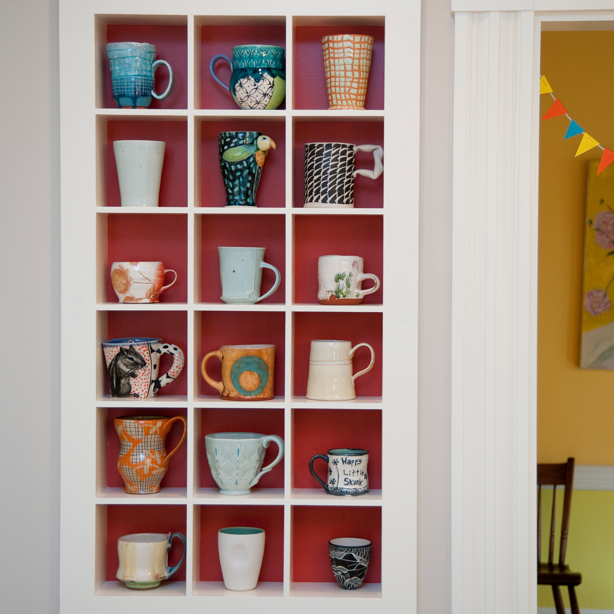 A built-in cabinet with separate compartments for mugs