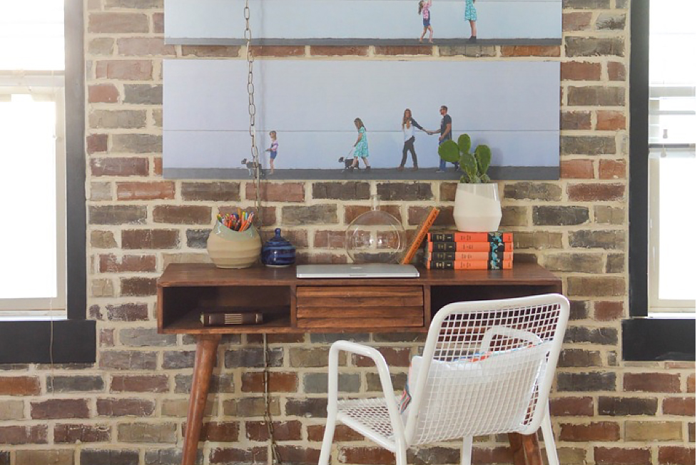 A brick wall in a living room with a workspace