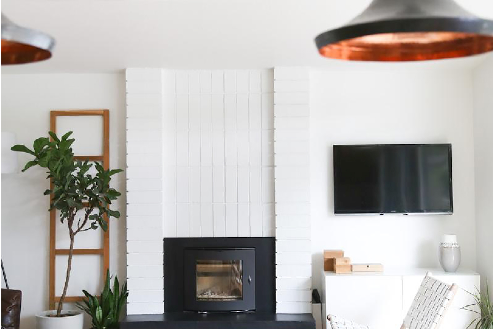 White living room with black fireplace and copper accents