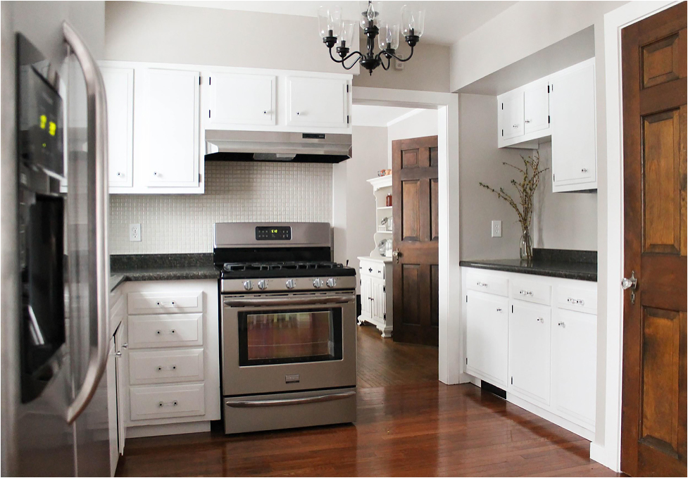 A kitchen with white cabinets and stainless steel appliances