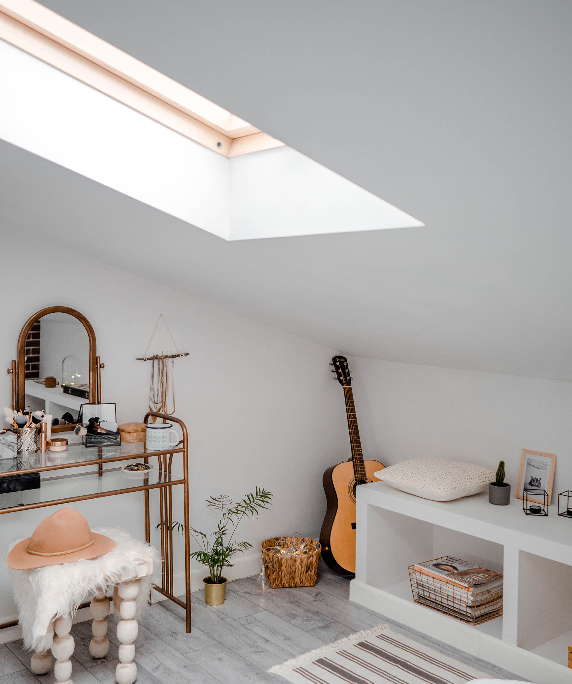 White attic with skylight above dressing table with stool