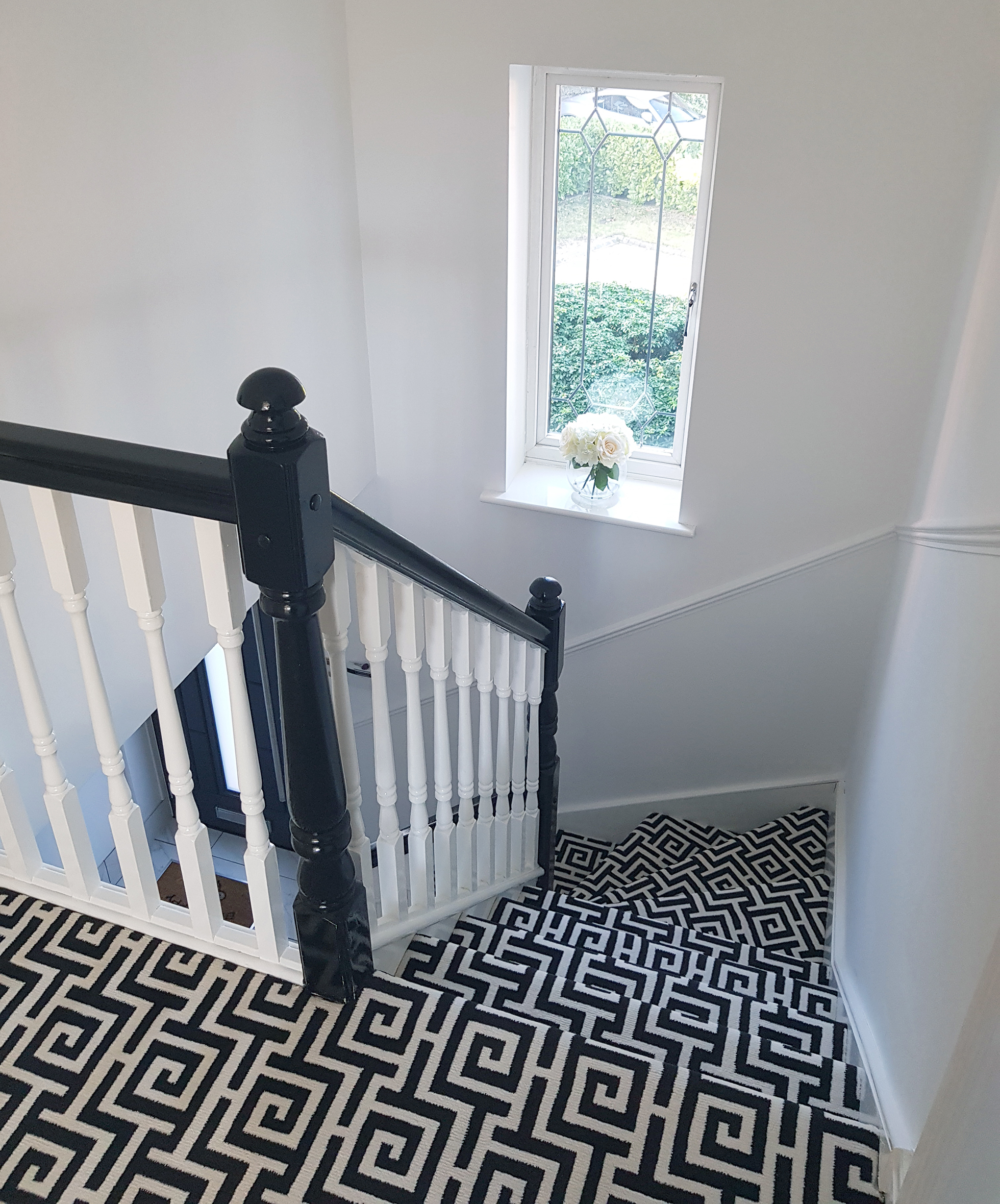 Spiral stairs covered in black and white geometric carpeting