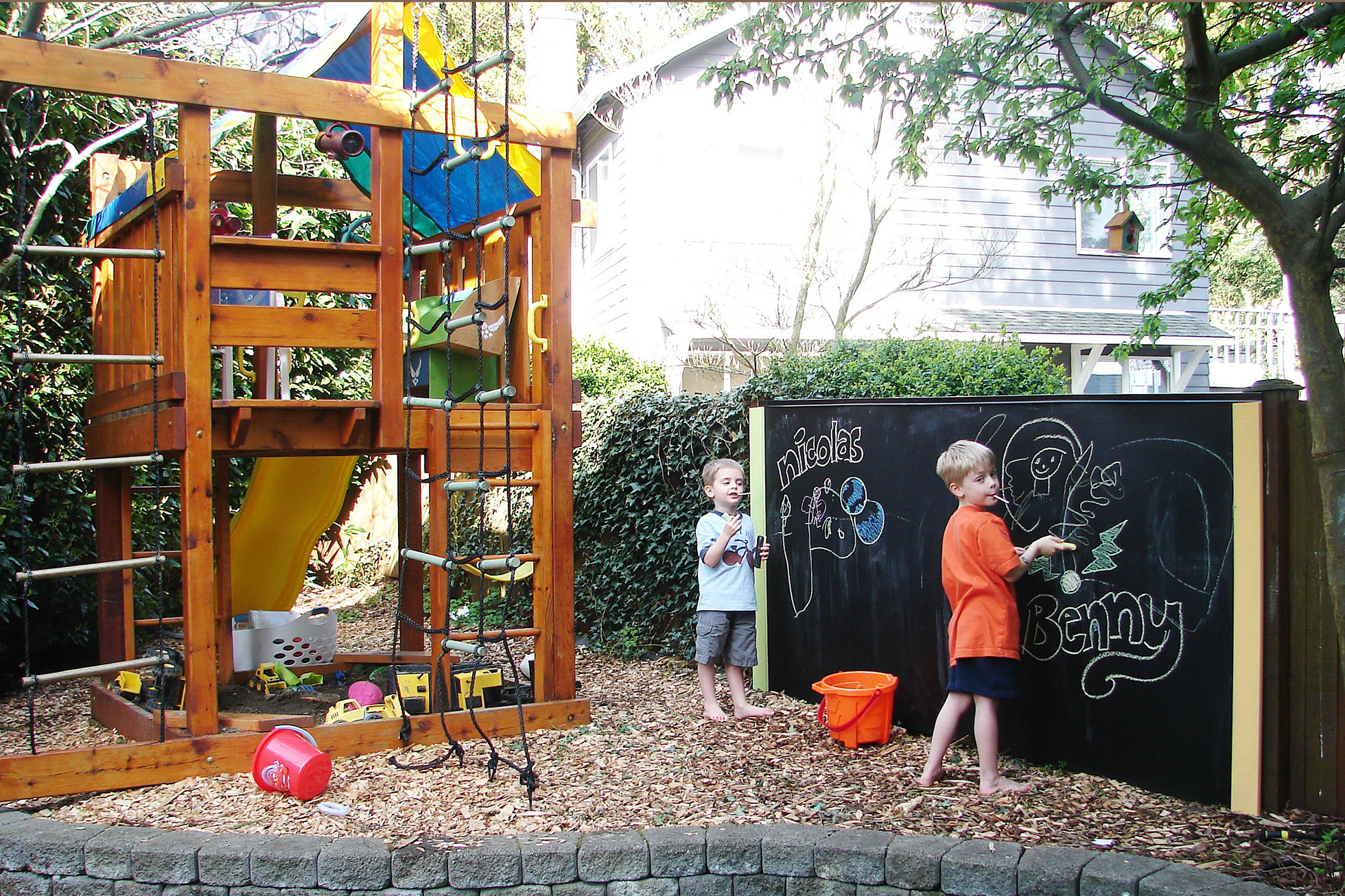 Outdoor space with kid-friendly playhouse and DIY chalkboard