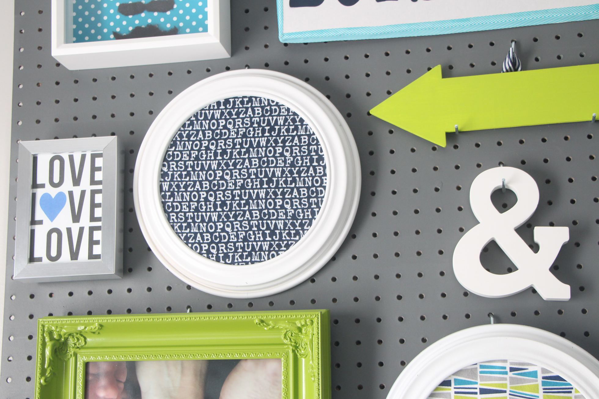 Gray pegboard with white and green frames