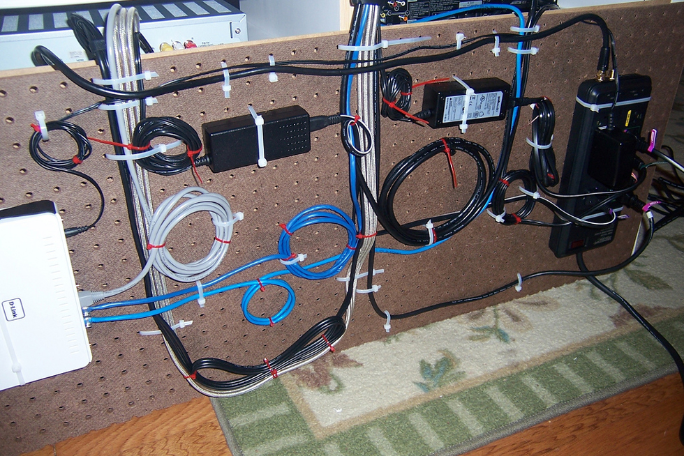Media cords on a pegboard behind a computer desk