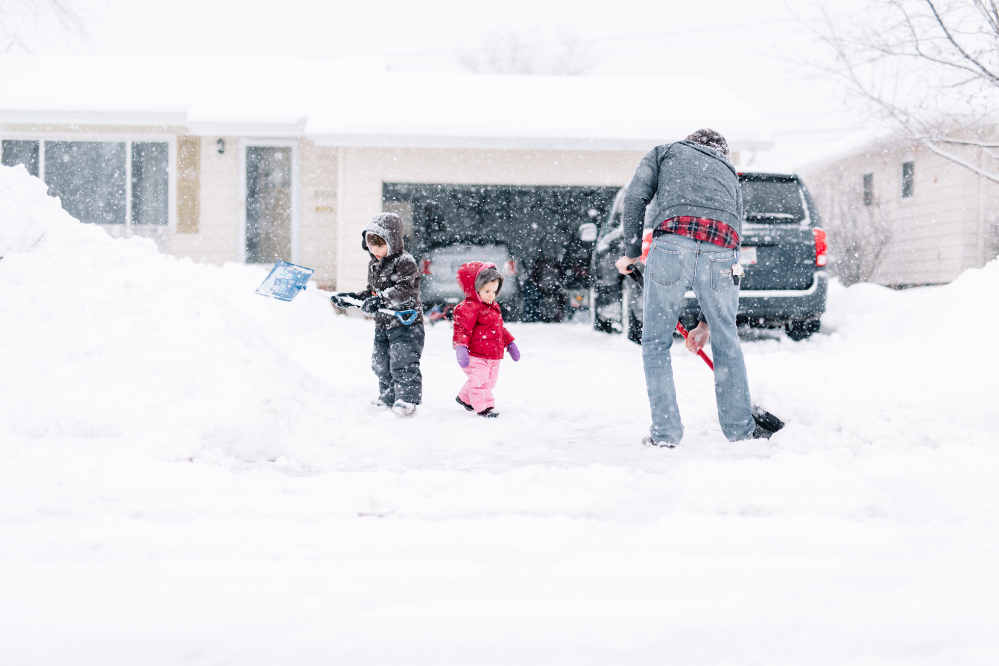 Father shoveling winter snow in his driveway