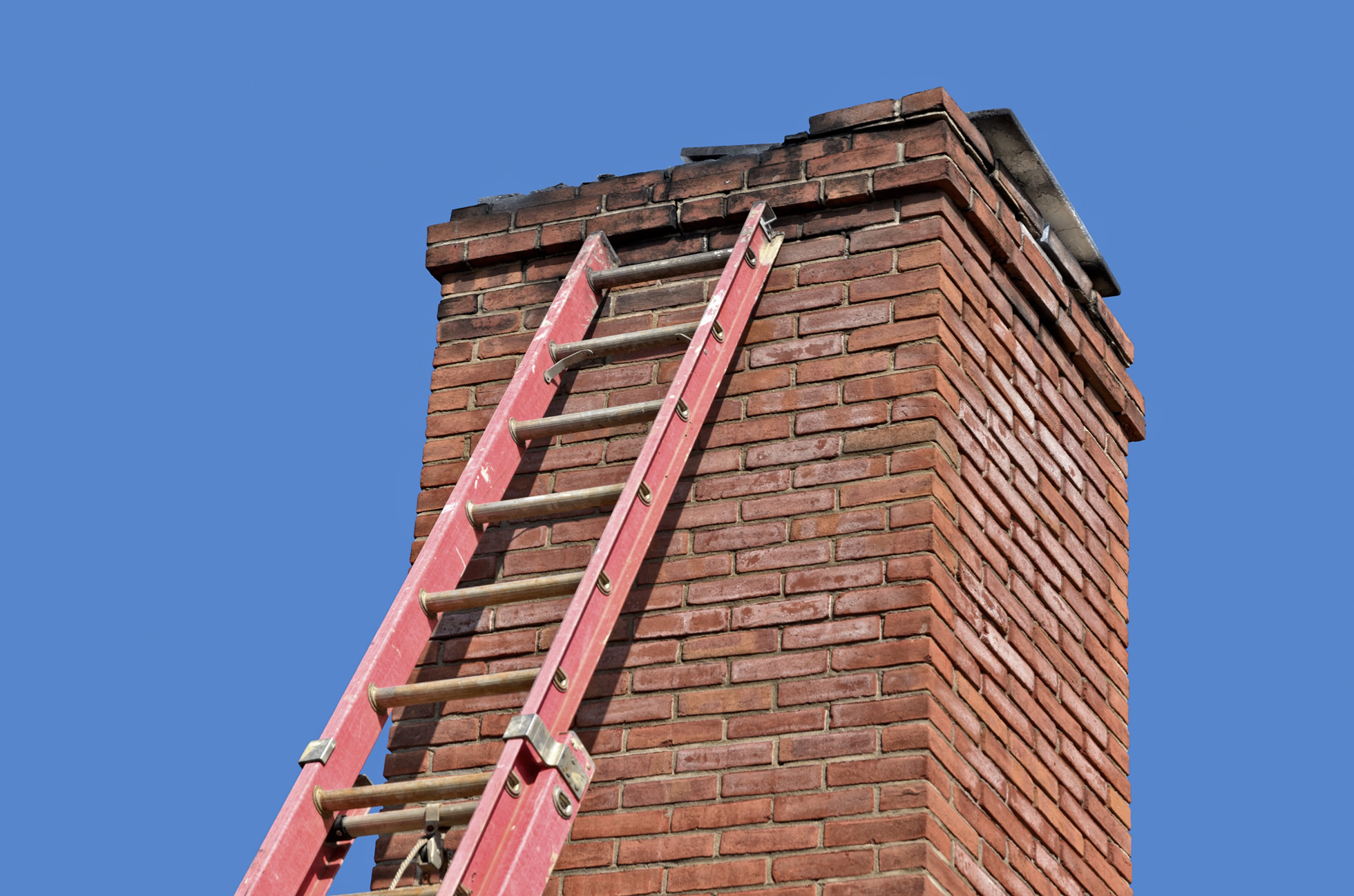 An old chimney with a ladder leaning against it