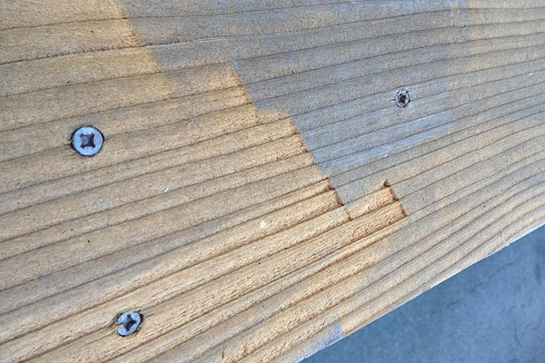 A deck board damaged by a power washer