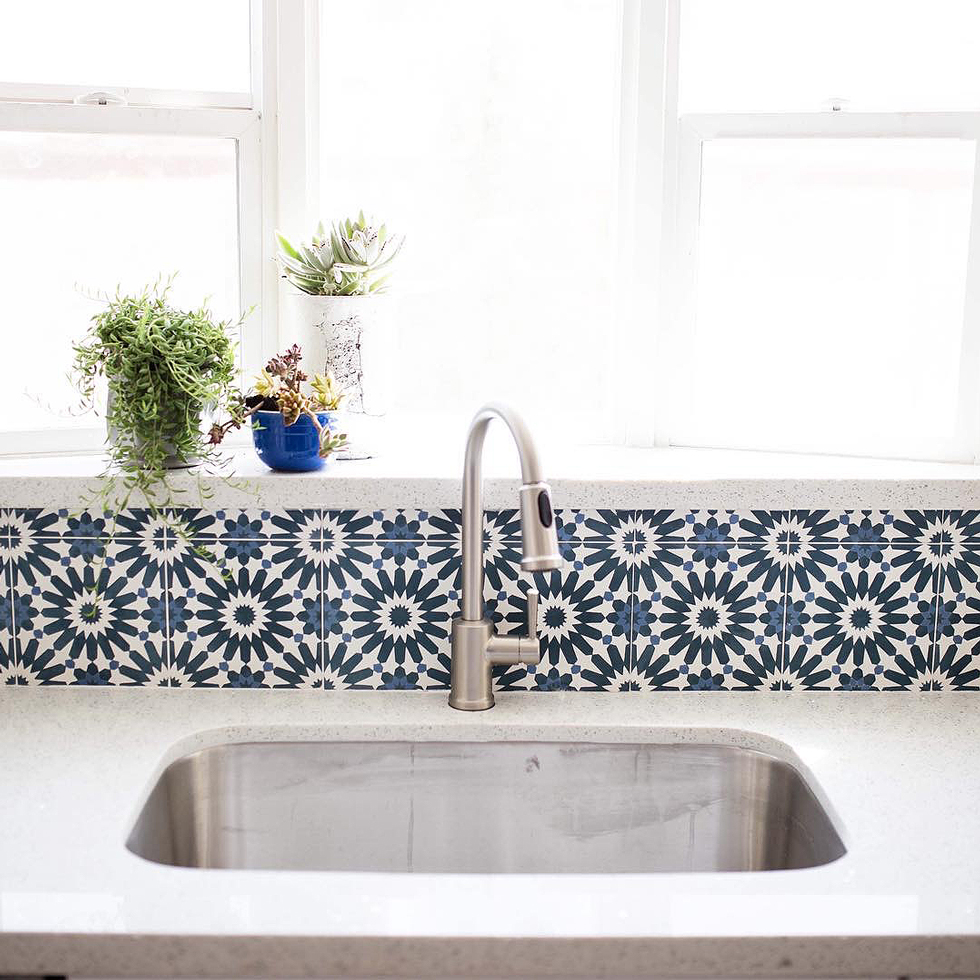 A blue and white tile backsplash behind a brass faucet