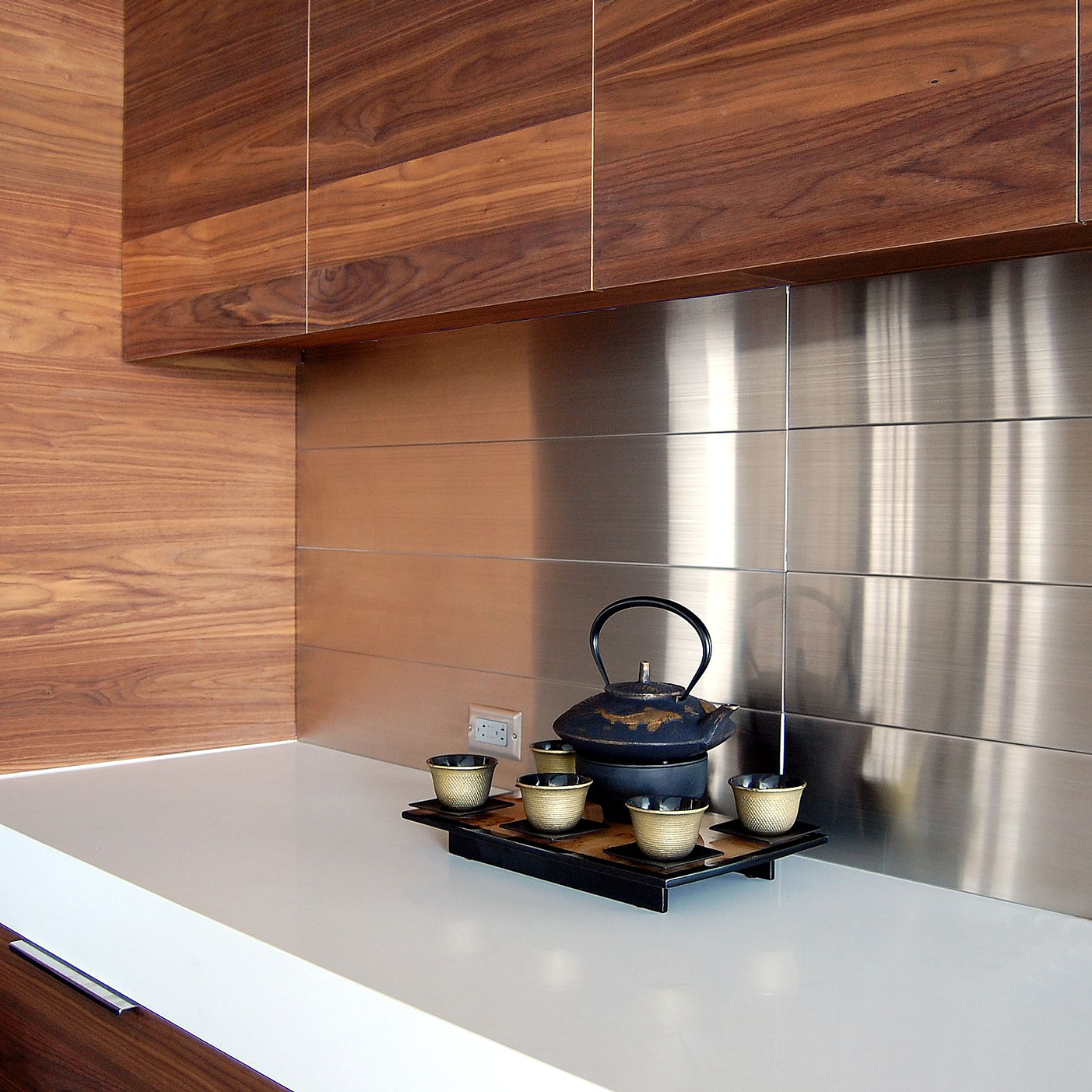 A stainless steel backsplash in a kitchen w/ wood countertop