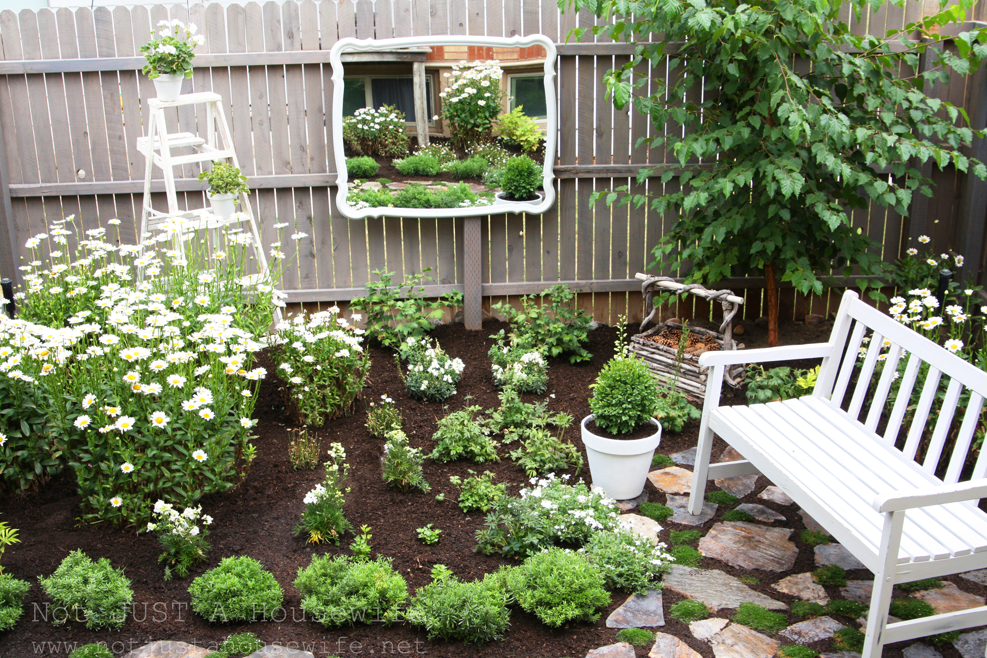 A mirror on a fence in an outdoor space with patio furniture