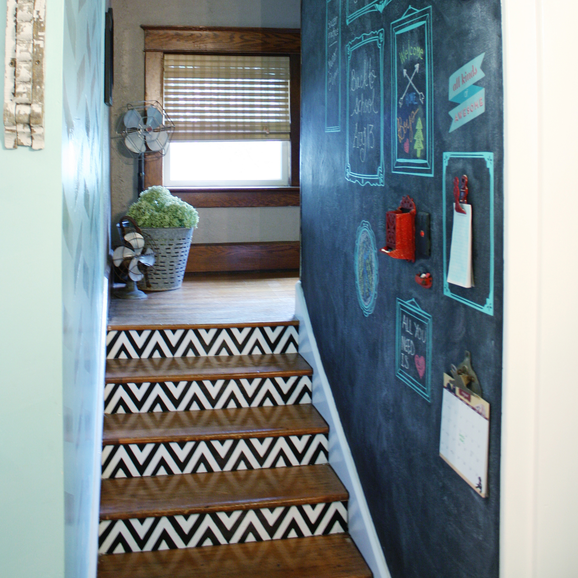 A black and white painted staircase and chalkboard wall
