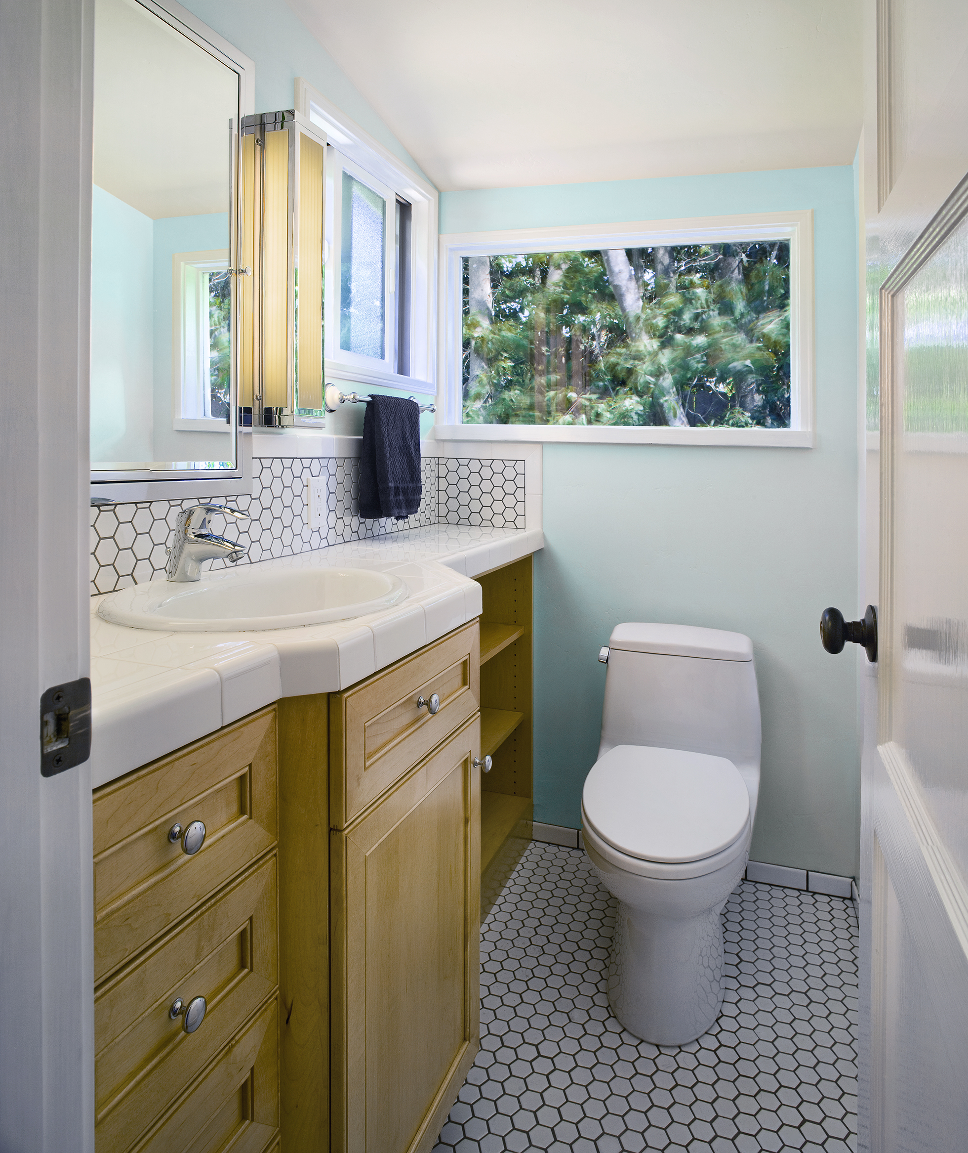 Light blue bathroom with white sink, toilet, and tile