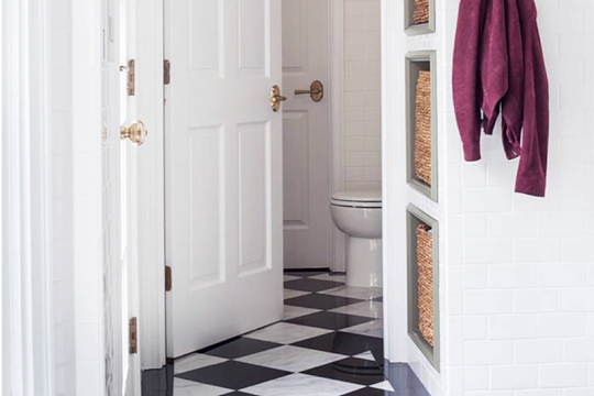 Outside of a bathroom with white and black flooring