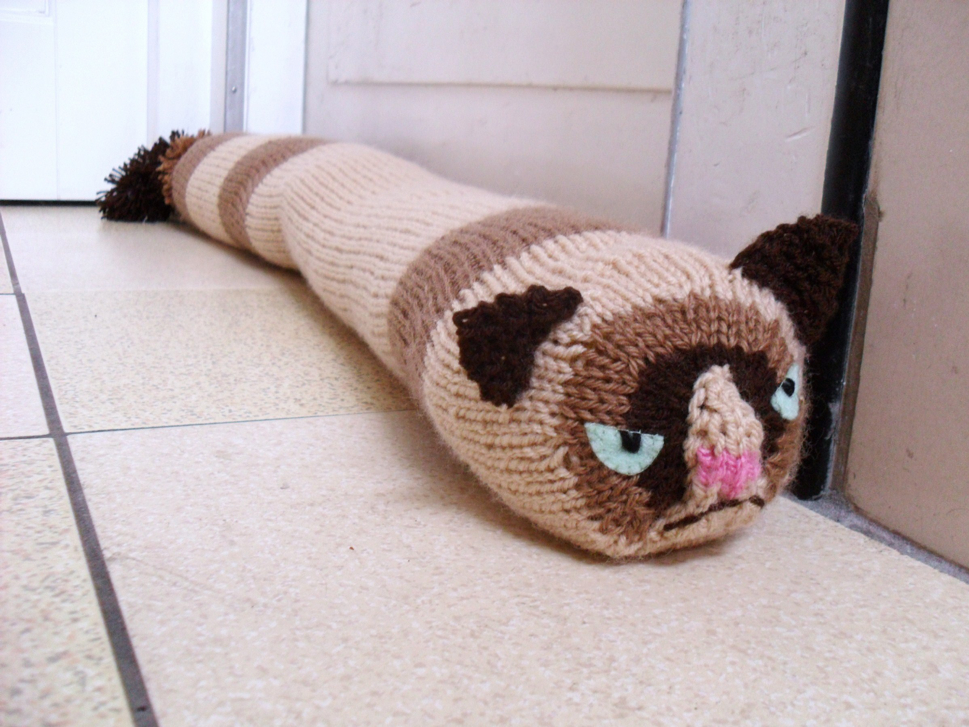 A grumpy cat door stopper
