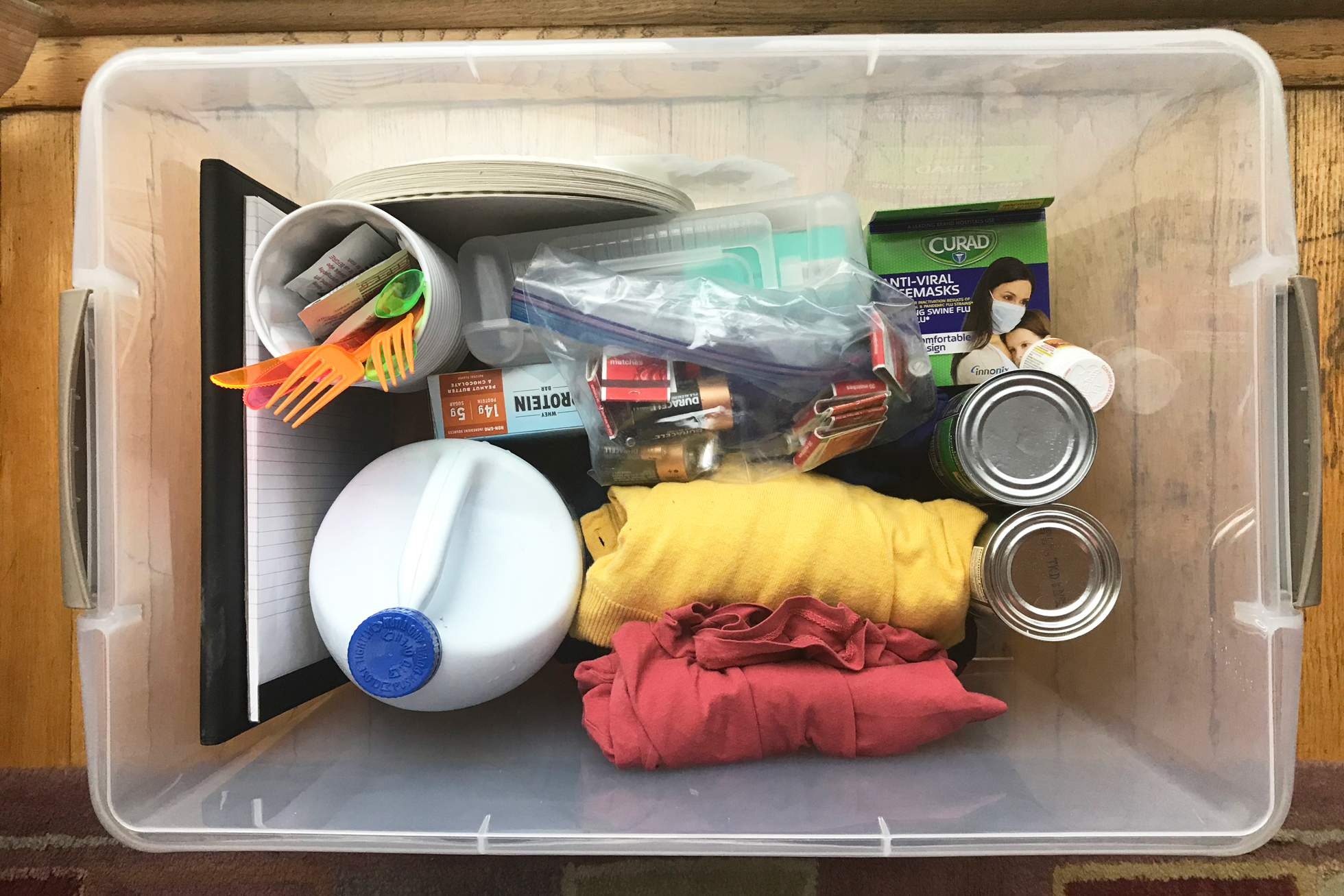A clear plastic bin filled with emergency supplies